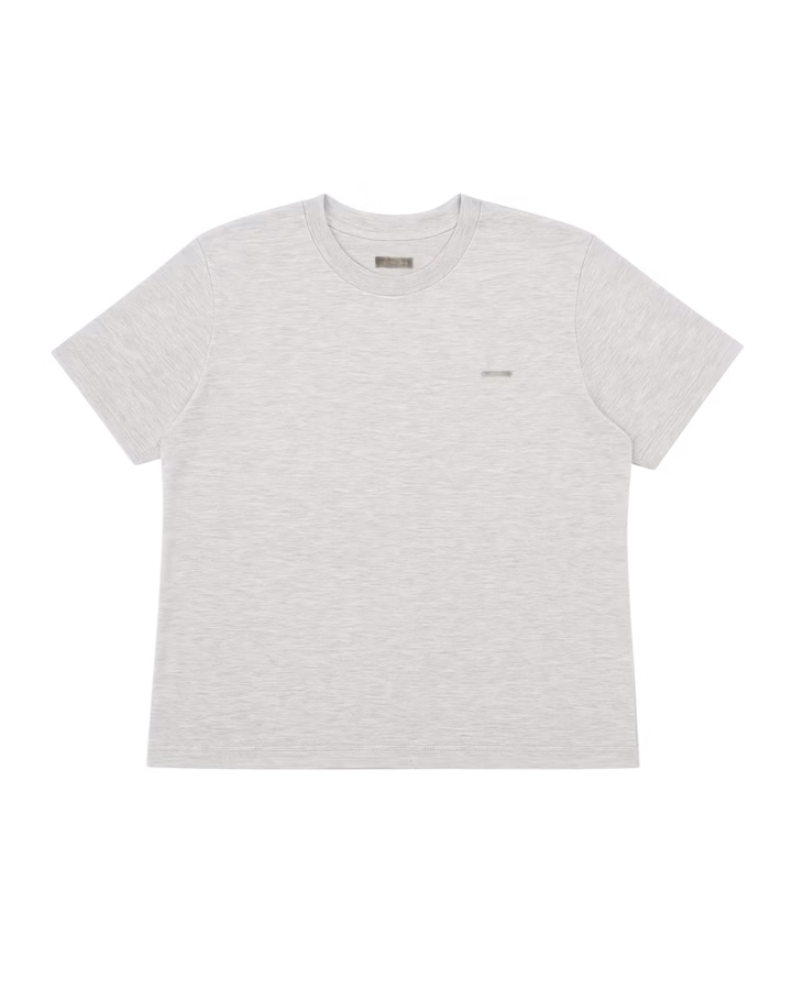 Remera Regular Básica Gris Melange de Its Fort Real, hecha de de jersey peinado de algodón 100%, con corte regular, mangas cortas y un dije acrílico de marca en el frente.