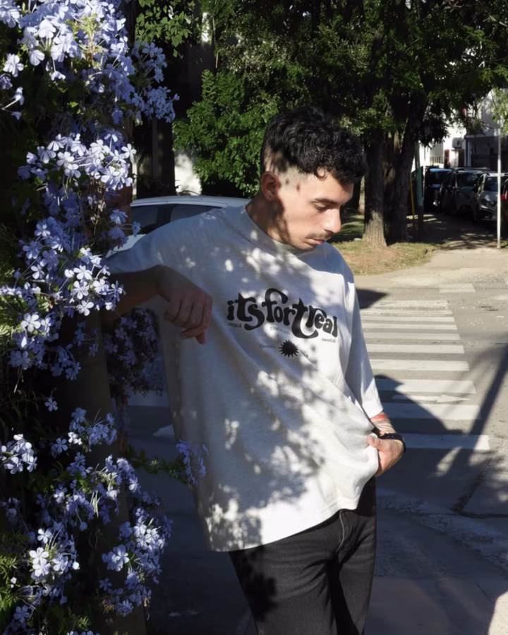 remera oversize color gris melange con manga corte ranglan y estampa en el frente con inscripcion