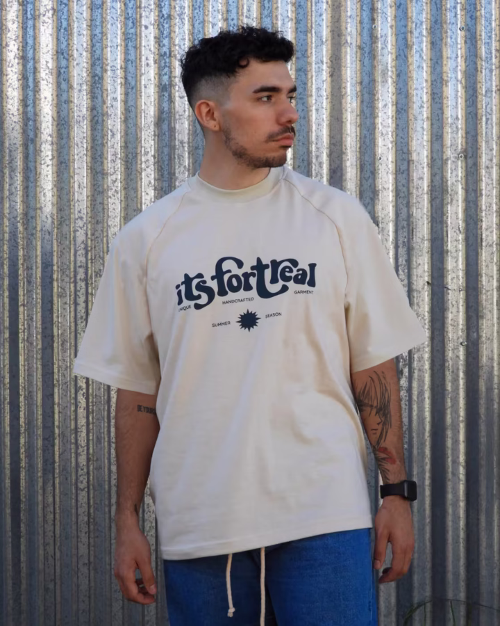 remera oversize color hueso con manga corte ranglan y estampa en el frente con inscripcion